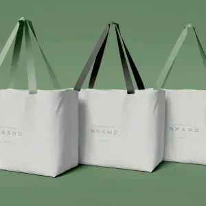 PSD Mockup Bag Product Design, Three white tote bags with different colored handles on green background