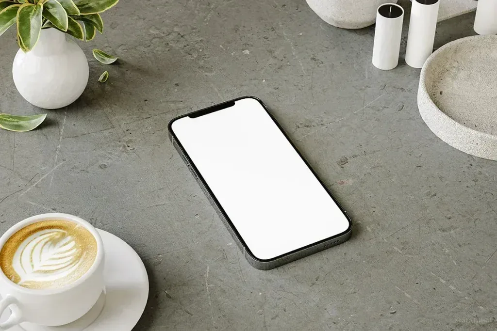 PSD Mockup Mobile Device on Coffee, Mobile device with blank screen on concrete coffee table with cup of coffee and plant
