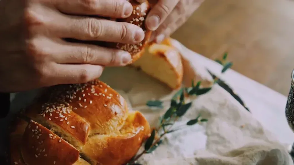 After Effects Project Cinematic Food Video Color, Hands breaking freshly baked sesame seed bread on a wooden table