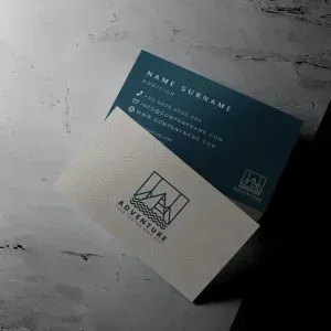 PSD Mockup Business Card on Clean, Two business cards on a textured concrete desk, one dark blue and one cream.
