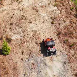 Aerial Red Buggy on Hilly Trail Stock Footage Aerial Red Buggy on Hilly Trail Stock Footage